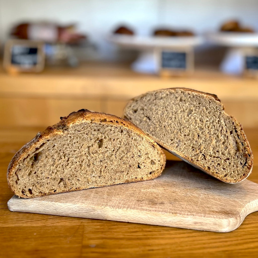 Dense, high-fiber 100% einkorn sourdough loaf sliced on board